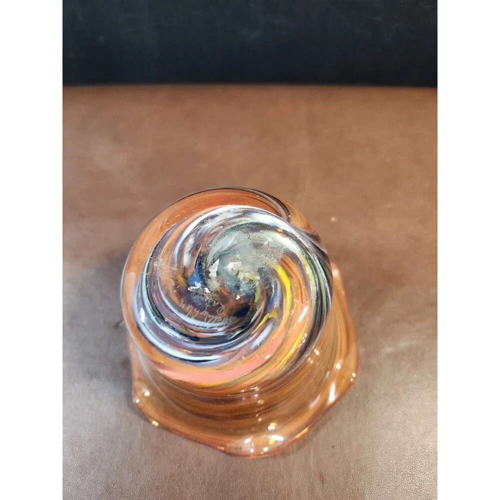 hand-blown art glass bowl features a vibrant orange and amber swirl pattern with